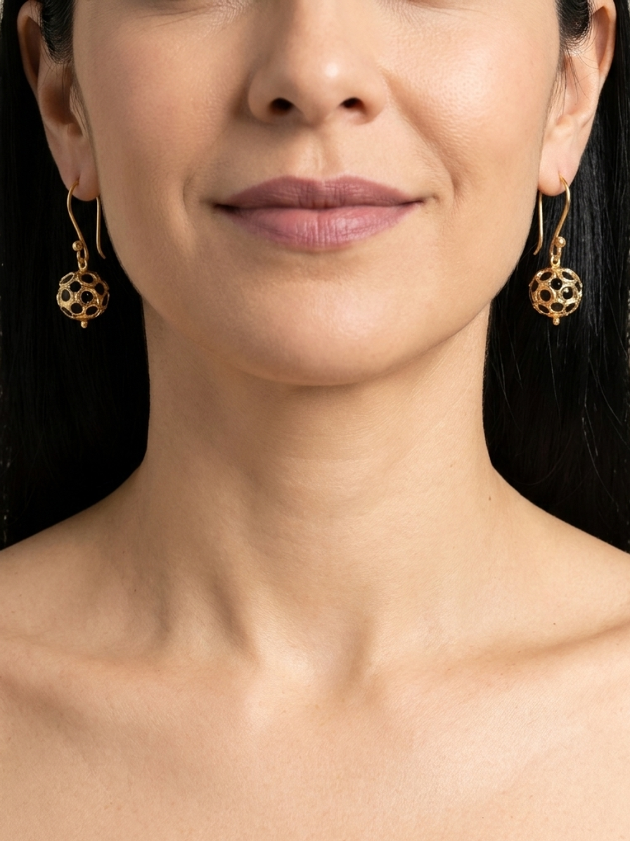 Noir Pavilion Drops — handmade gold-tone openwork metal jewelry by Sima & Sid, shown on a model